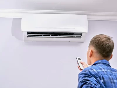 man turns air conditioner with remote control home 154092 554