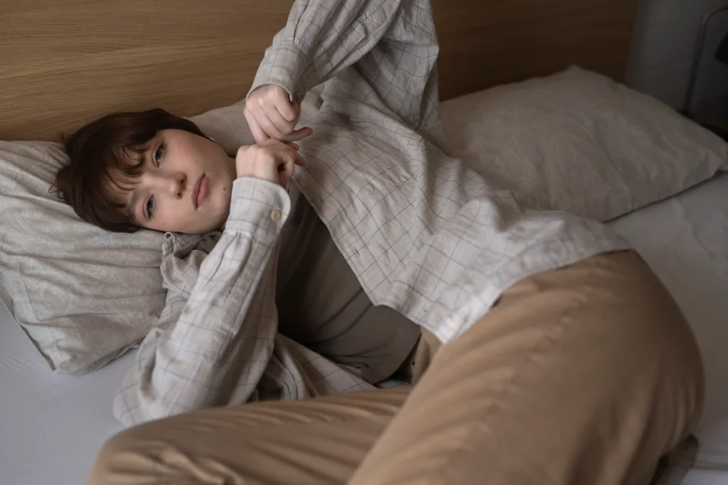 medium-shot-young-sad-woman-laying-bed-scaled