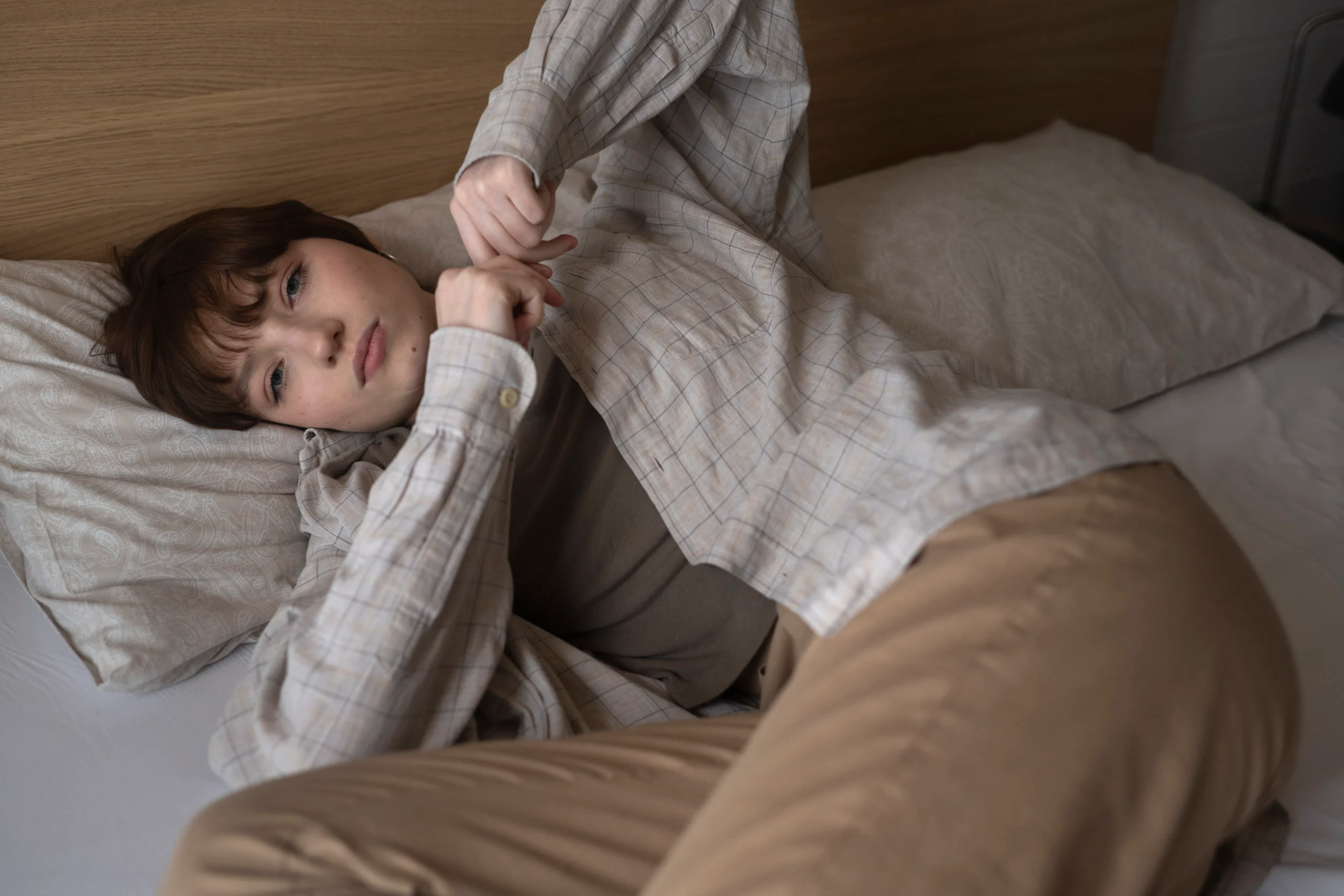medium-shot-young-sad-woman-laying-bed-scaled