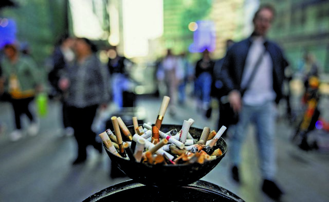 People walk by an ashtray in the street in Moscow