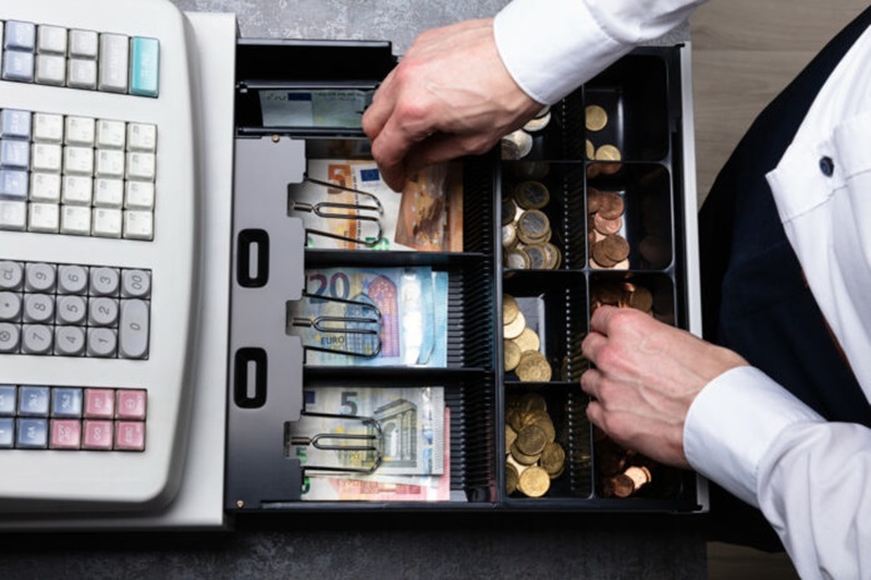 An,Overhead,View,Of,Cashier's,Hand,Taking,Banknote,From,Opened