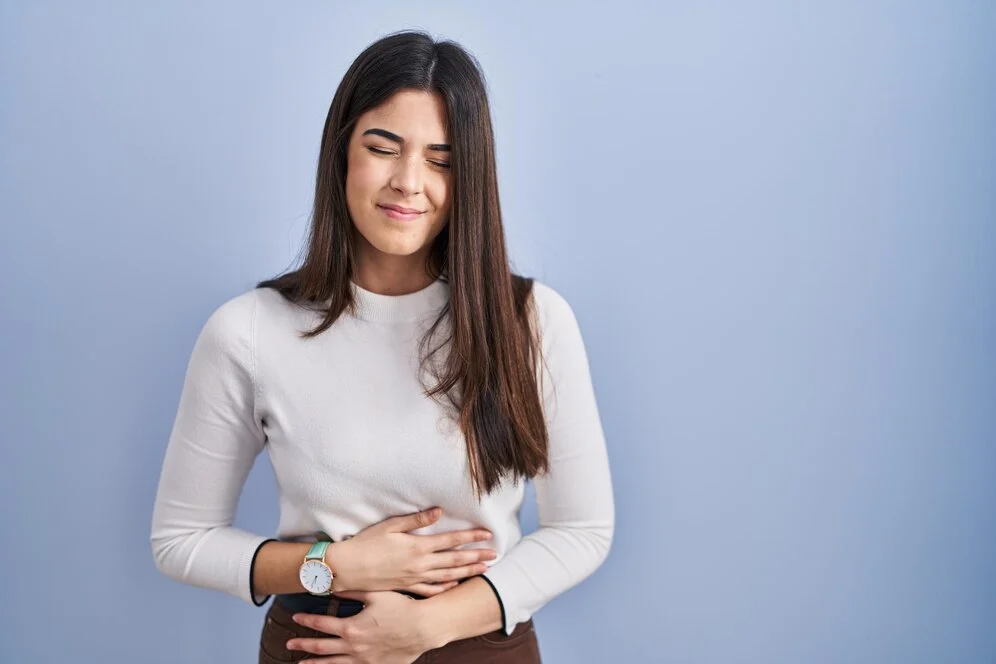 young-brunette-woman-standing-blue-background-with-hand-stomach-because-indigestion-painful-illness-feeling-unwell-ache-concept_839833-13927