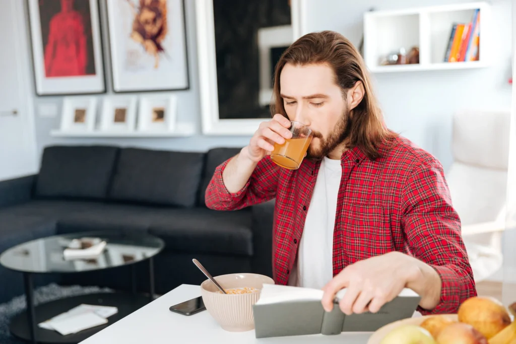 handsome-man-eating-breakfast-reading-book-home-scaled