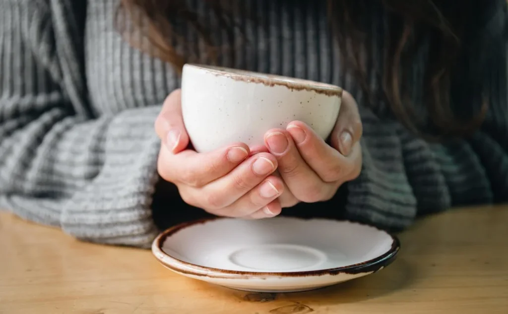 closeup-white-cup-female-hands-blurred-background