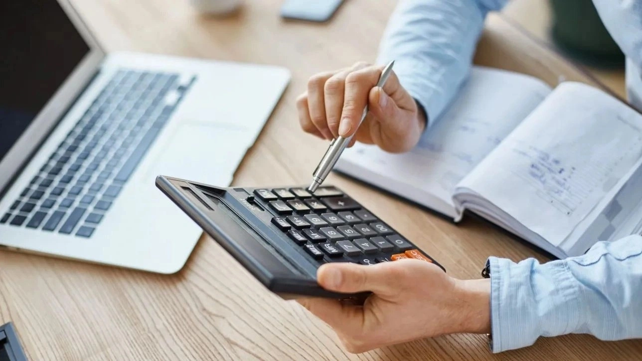 9622ba9b-6f200ead-cropped-view-professional-serious-finance-manager-holding-calculator-hands-checking-company-month-s-profits