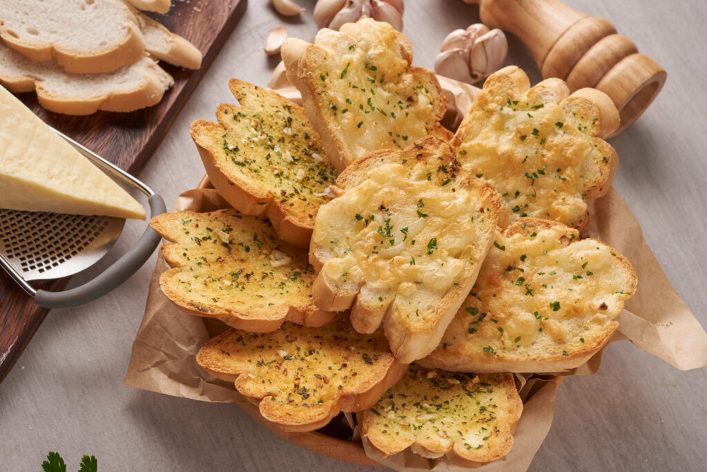 Homemade tasty bread with garlic, cheese and herbs on kitchen ta