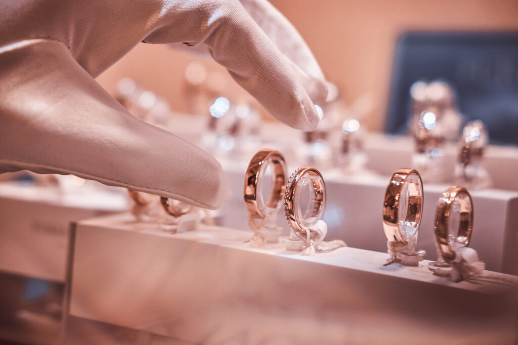 Hand in gloves takes to exclusive rings on the showcase of a jewelry store