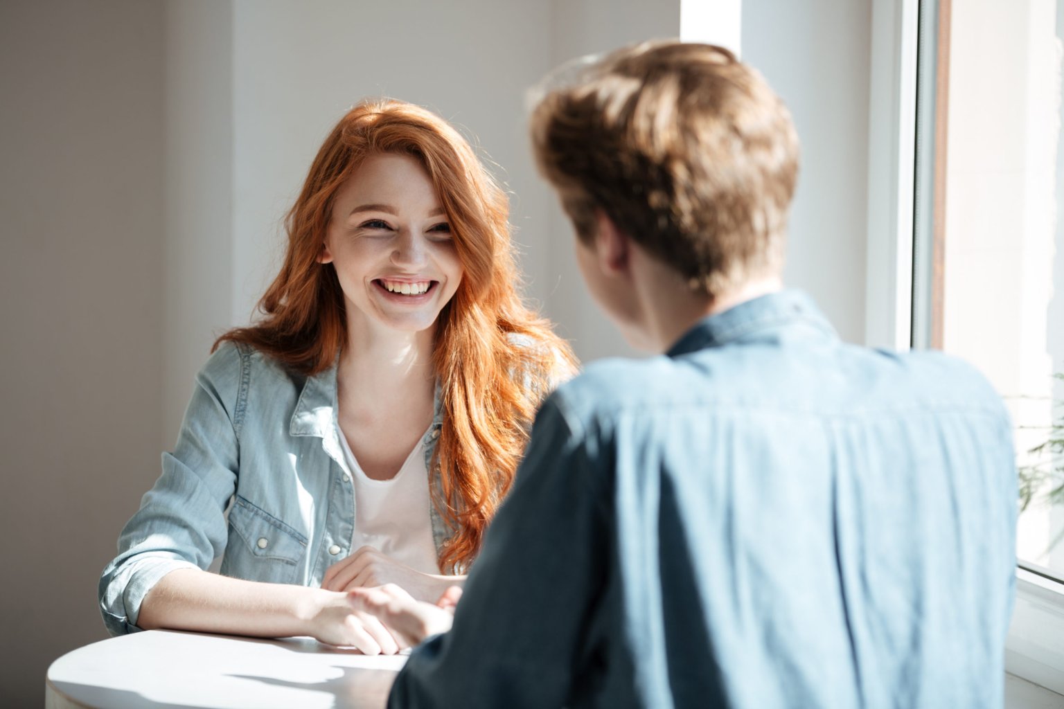 young-woman-laughing-cafe-scaled